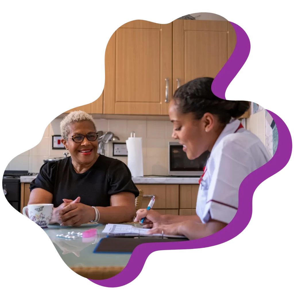 Nurse at home with happy woman going through medical records