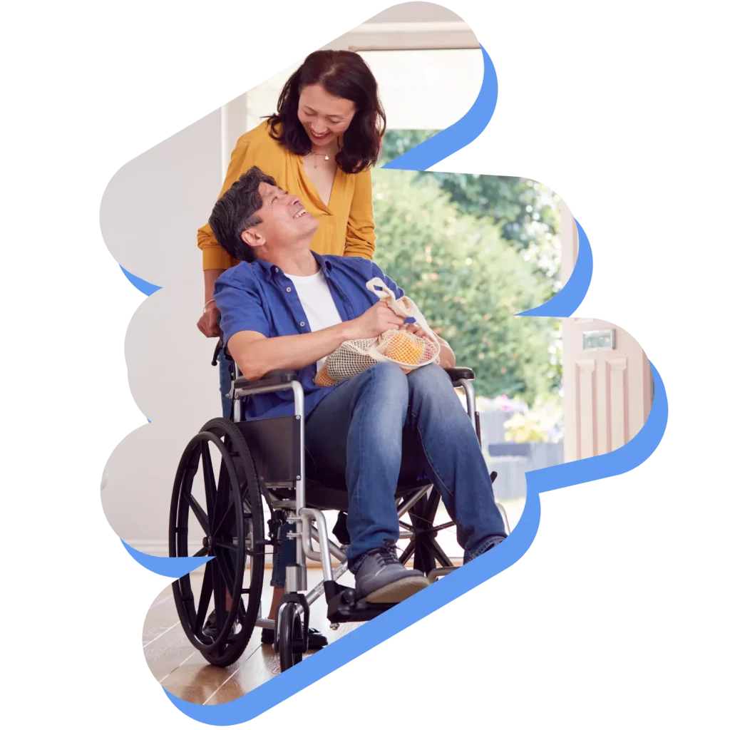 Wife looking down and smiling at disabled husband in wheelchair